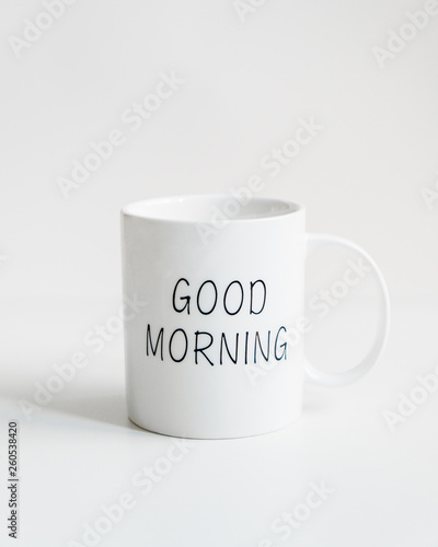 White mug with black inscription good morning. Festive table setting for holiday. On a white background. Front view. Tableware. Isolated.