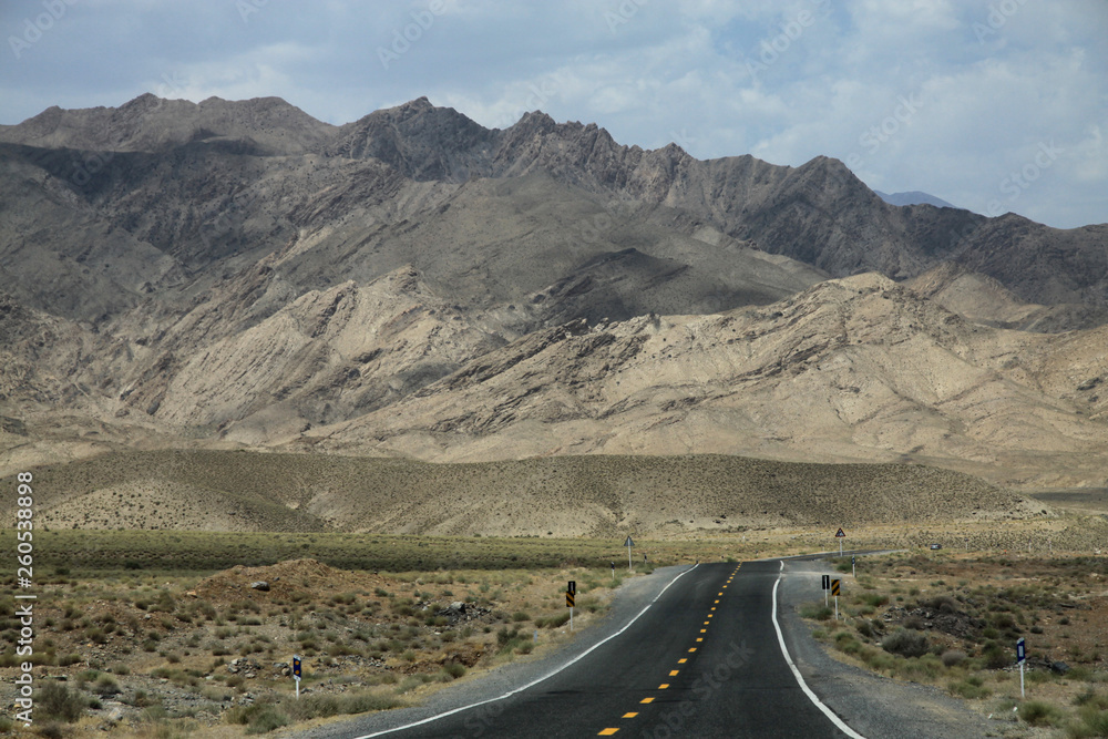 długa prosta asfaltowa droga biegnąca w stronę gór w iranie