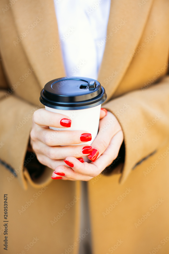 Female hands holding cup of coffee to go.
