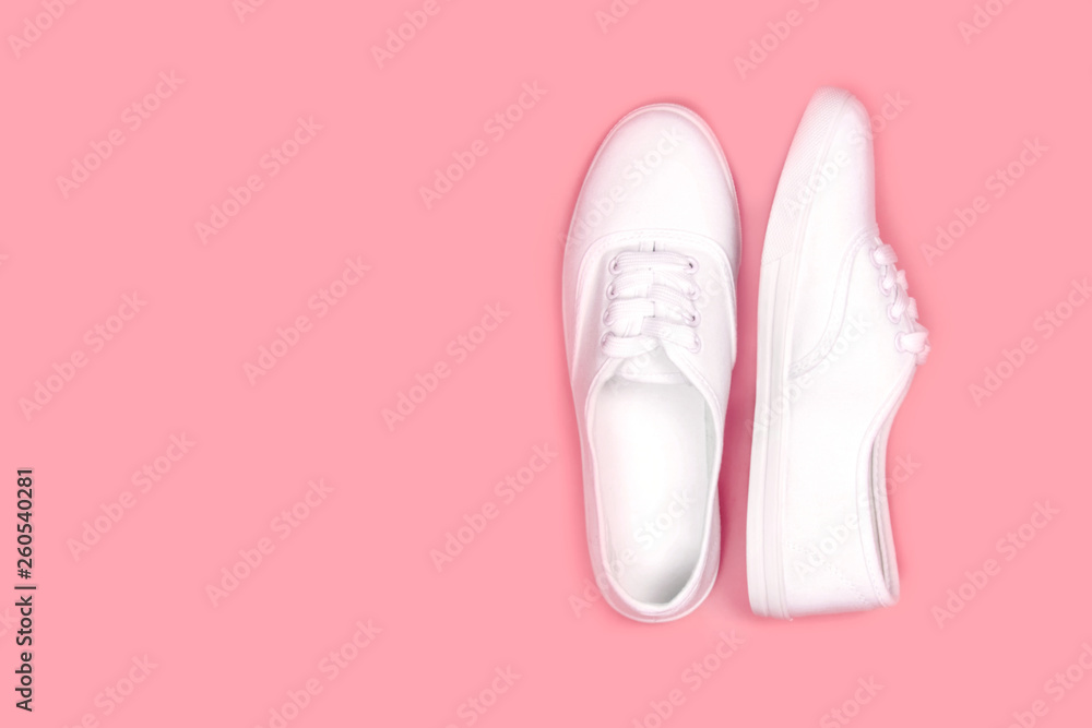 White sneakers on pink background, flat lay,copy space..Fashion trend shoe