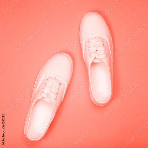 White sneakers on a coral background