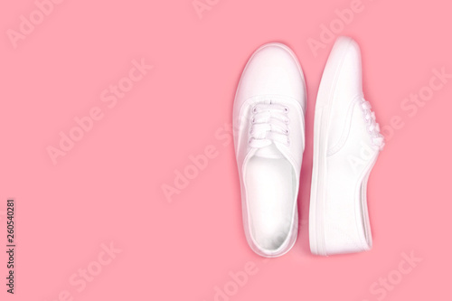 White sneakers on pink background, flat lay,copy space..Fashion trend shoe