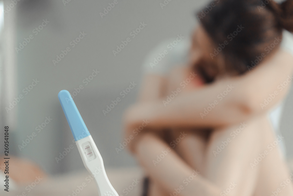 Naklejka premium Young asian woman looking at pregnance test.