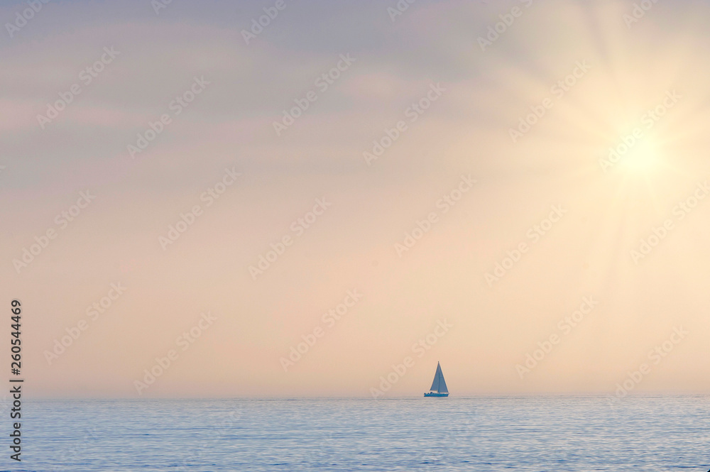 sailboat on the horizon in a summer sunset