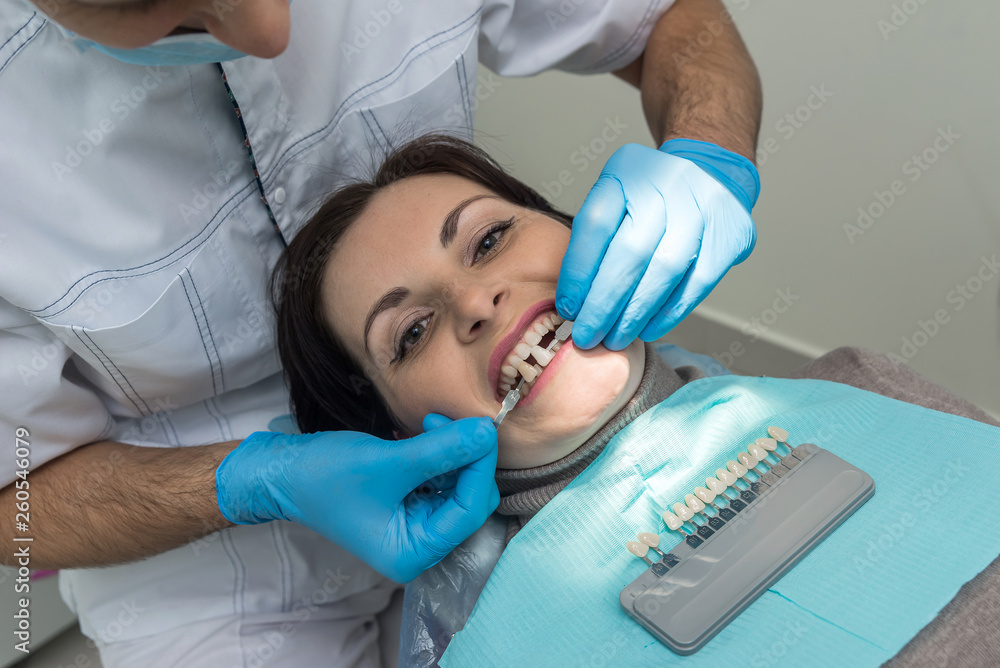 Dentist hands with teeth samples comparing to patient Dentist hands with teeth samples comparing to patient