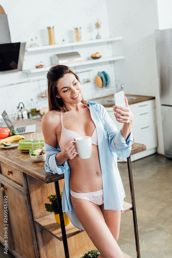 Sexy girl in white lingerie holding cup of coffee and taking selfie  Stock-Foto | Adobe Stock