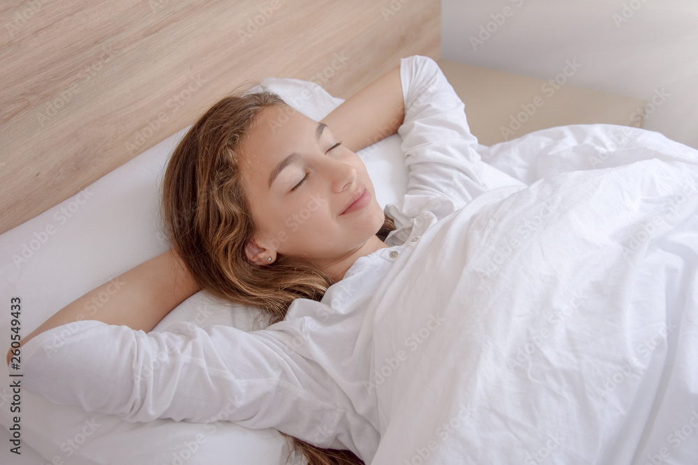 Pretty lady lies in bed indoors with eyes closed Pretty lady lies in bed indoors with eyes closed