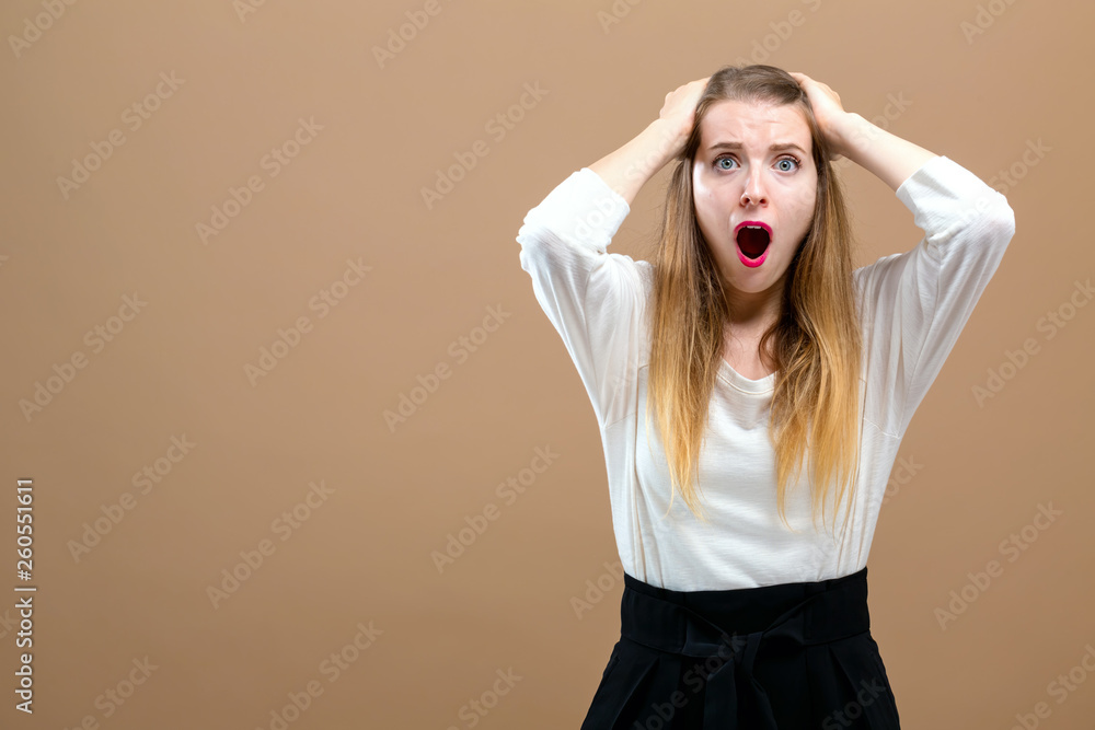 Young woman making a mistake on a brown background Young woman making a mistake on a brown background