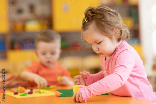 Nursery babies play with plasticine in kindergarten
