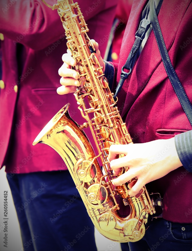 Naklejka premium young player plays the saxophone