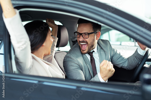 Happy beautiful couple is choosing a new car at dealership © zorandim75