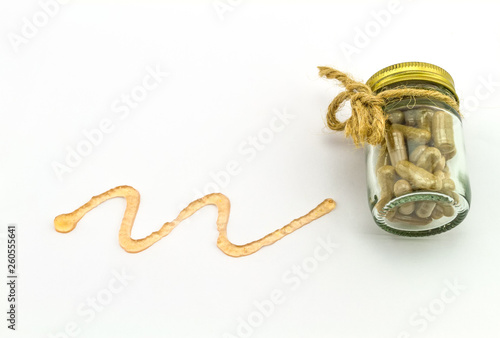 Close up spiral curve of orange liniment gel and pill  isolated on white background.