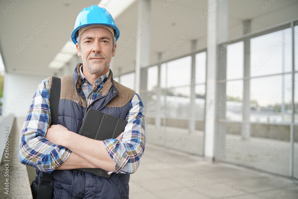 Construction worker looking at camera outside contemporary building Construction worker looking at camera outside contemporary building