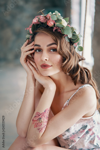 Beauty portrait of young woman with wreath of flowers in hair