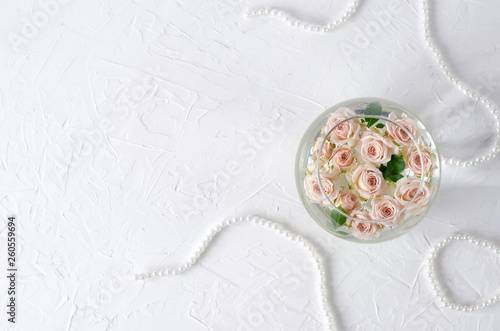 Round vessel with water and small peach roses.