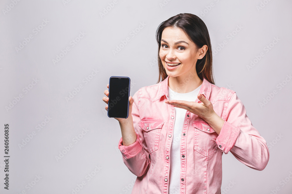 Portrait of a smiling cheerful woman showing blank smartphone screen isolated on a white background Portrait of a smiling cheerful woman showing blank smartphone screen isolated on a white background