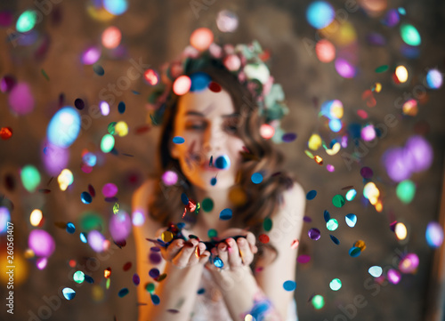 Young beautiful women blowing confetti from hands