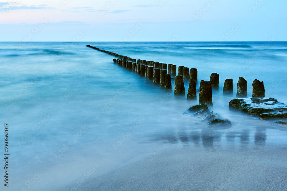 Wooden breakwater on the Baltic coast in the evening in Poland.