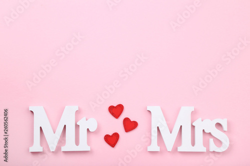 White letters Mr and Mrs with red hearts on pink background