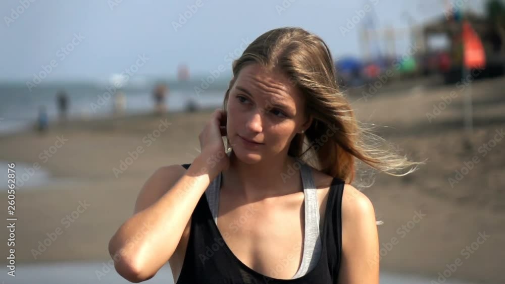 Young, pensive woman walking on the beach, slow motion Young, pensive woman walking on the beach, slow motion