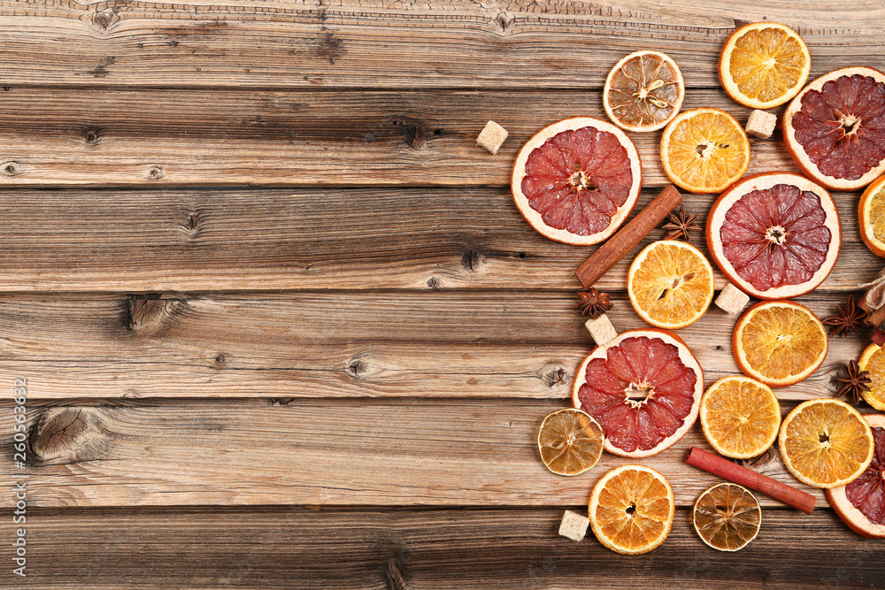Dried citrus fruits with cinnamon, star anise and sugar cubes on brown wooden table Dried citrus fruits with cinnamon, star anise and sugar cubes on brown wooden table