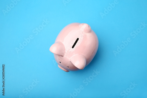 Pink piggy bank on blue background
