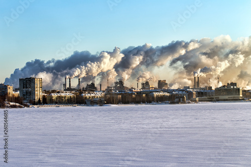 Environmental problem of environmental pollution and air in large cities. Smoke from factory pipes above city photo