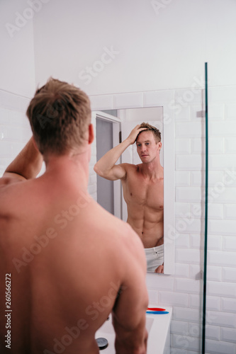 Handsome athletic men shirtless at front reflection the mirror in the bathroom