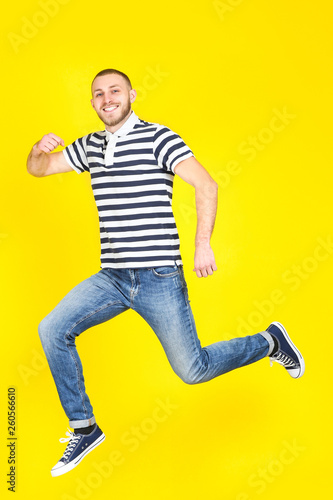 Jumping young man on yellow background
