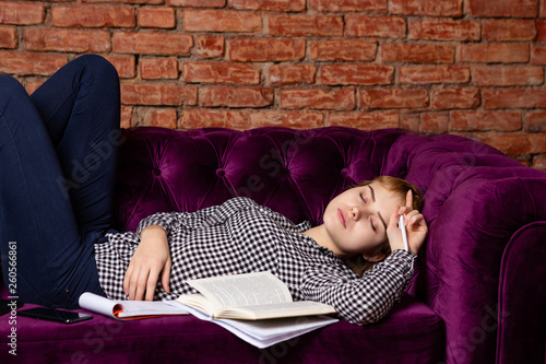 Overexhausted student girl sleeping on sofa. photo