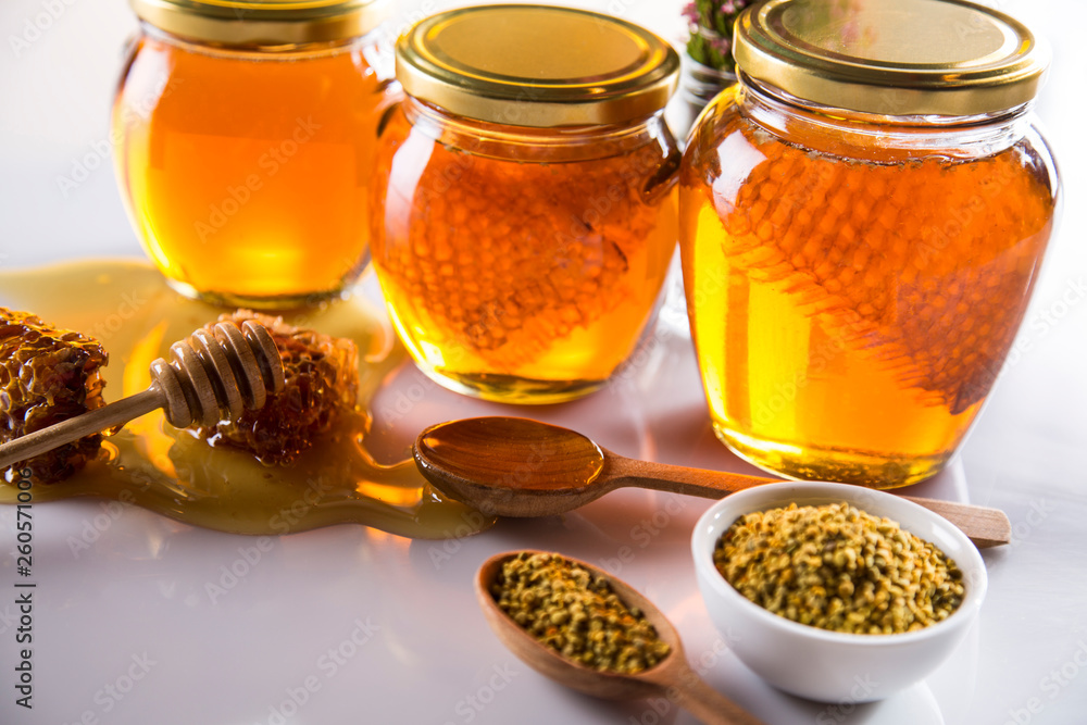 Honey in jar with honey dipper on wooden background Honey in jar with honey dipper on wooden background