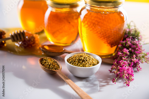 Honey in jar with honey dipper on wooden background