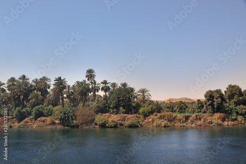 Landschaft am Ufer des Nil mit Palmen und Wüse im Hintergrund, blaues Wasser und blauer Himmel © Holger T.K.
