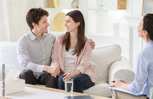 Professional therapist and happy couple in office