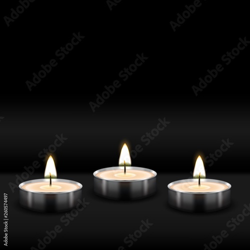 Three tealight burning realistic candles on black background
