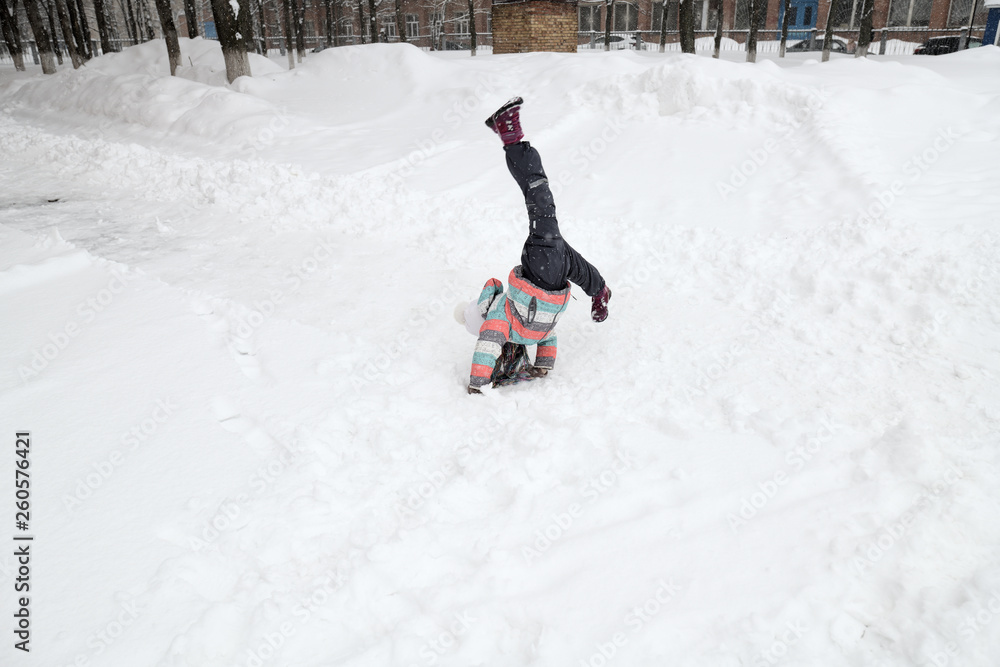 little girl doing flips on the snow