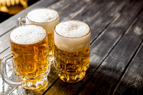 Mugs of fresh foamy beer on the bar table. 