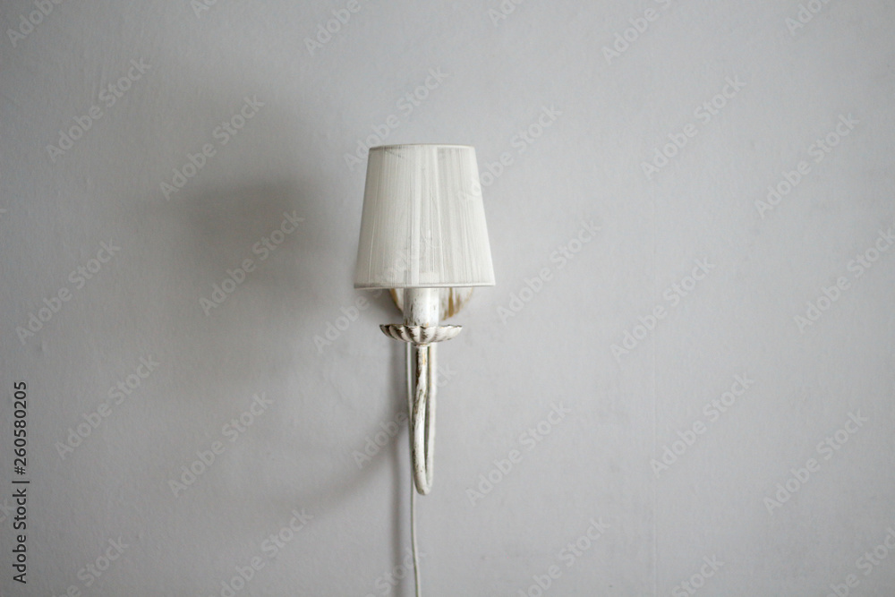 Lamp sconces on a gray wall with shadows in the interior design room with free copy space for text Lamp sconces on a gray wall with shadows in the interior design room with free copy space for text