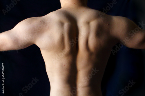 torso of brutal muscular fitness athlete of a sporty man against black background
