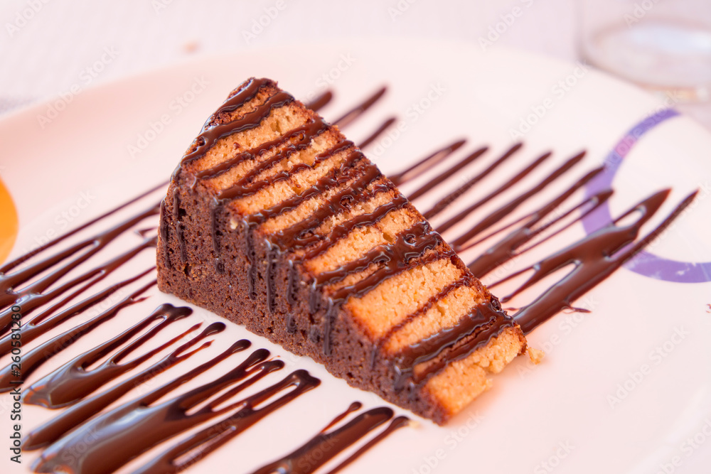 Portion of sponge cake with chocolate on plate Portion of sponge cake with chocolate on plate
