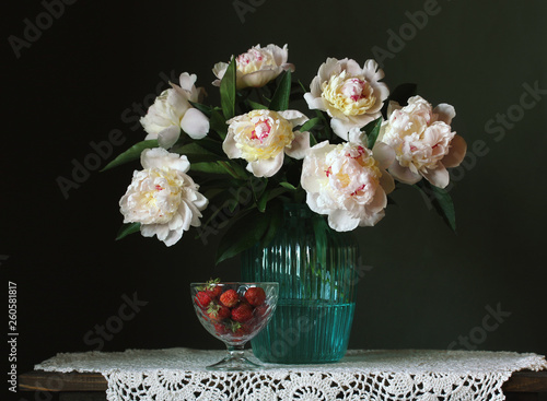 bouquet of white peonies and strawberries on a dark background.