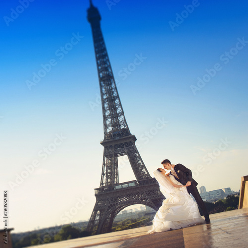     Beautiful wedding couple has fun posing on the square before the Eiffel Tower in Paris © Igor