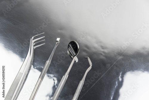 Set of professional dentist tools on gray metal background. Dental hygiene and health concept © strigana