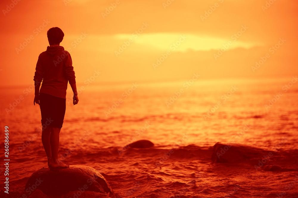 landscape sunset on the sea, man on the lake shore at sunset, beautiful place  nature, water and seashore, concept of waiting for loneliness