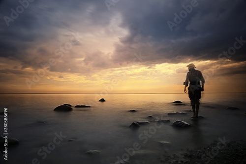 landscape sunset on the sea, man on the lake shore at sunset, beautiful place nature, water and seashore, concept of waiting for loneliness