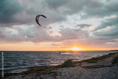 Kite surfing with high speed on the sea at sunset © Mikkel H. Petersen