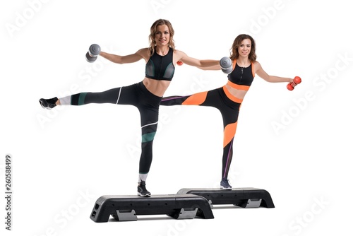 Fototapeta Naklejka Na Ścianę i Meble -  Women exercising on step platform isolated shot