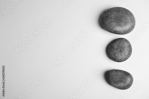 Zen stones on white background, top view with space for text