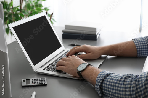 Man working with laptop at table, closeup. Space for design