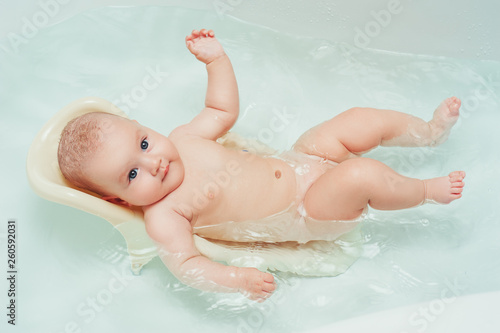 Portrait of baby infant girl having a bath and smiling. People babycare family lifestyle medicine hygiene concept